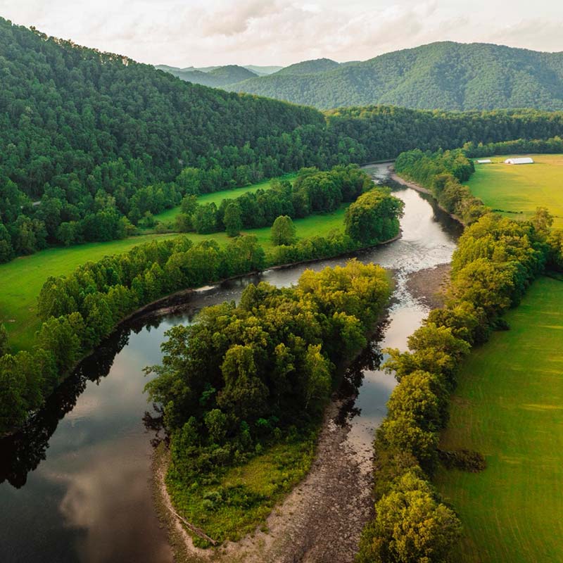 Arial view of Cheat River winding through green forested mountains near Parsons, West Virginia.