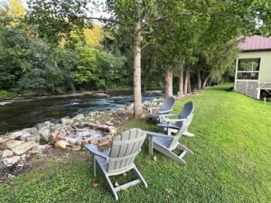 Parsons Riverside Retreat exterior view of chairs and fire pit on the river bank.