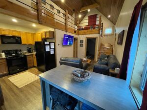 Parsons Riverside Retreat interior view of kitchen, living room, and upstairs loft.