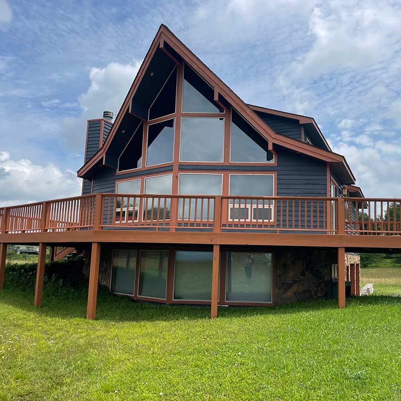 View from back yard of large two-story home with wrap around deck built by Performance Construction Services.